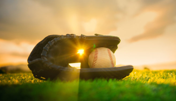Baseball in glove in the lawn at sunset. Play Ball! A Secure Opening Day at an Iconic Ballpark.