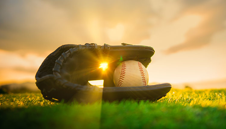 Baseball in glove in the lawn at sunset. Play Ball! A Secure Opening Day at an Iconic Ballpark.