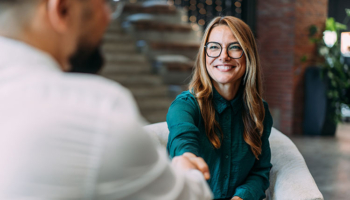 Two businesspeople shaking hands. Hire Your Replacement.